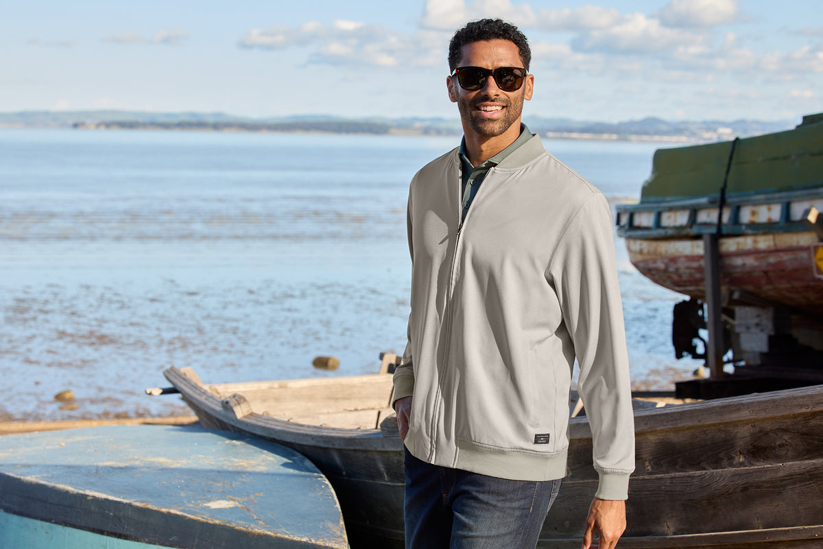 TravisMathew Bomber Jacket in Italian Sand, view on model