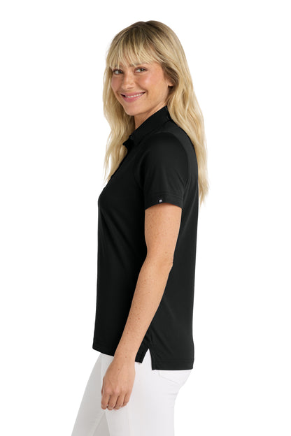 TravisMathew Women's Oceanside Solid Polo in Black, side on model